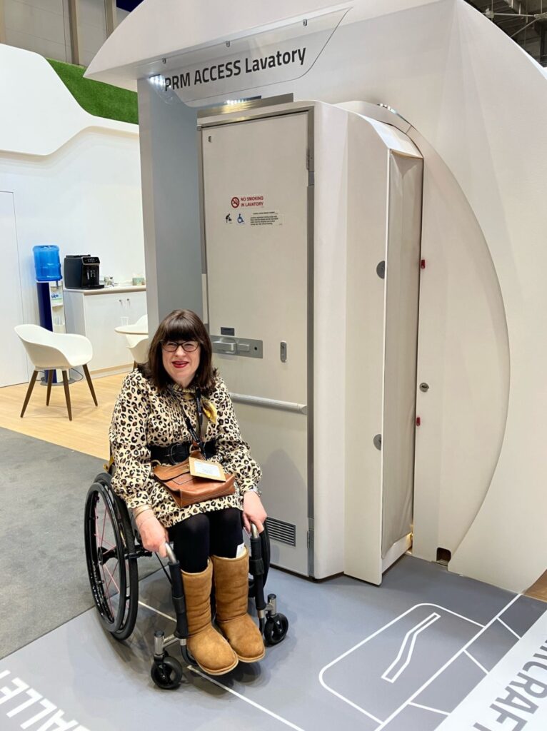 Rocket Girl Coaching's Mary Doyle in front of the ST Engineering ACCESS expanded lavatory